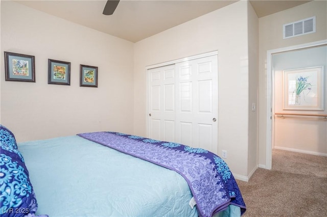 carpeted bedroom featuring a ceiling fan, baseboards, visible vents, and a closet