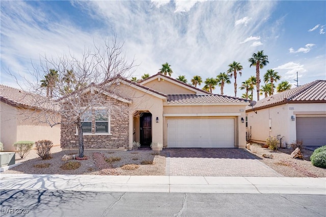 single story home with a tiled roof, decorative driveway, an attached garage, and stucco siding