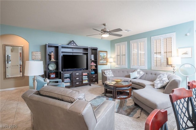 living room featuring light tile patterned flooring, visible vents, baseboards, and ceiling fan