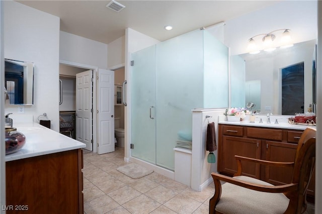 bathroom featuring tile patterned flooring, visible vents, a shower stall, and a sink