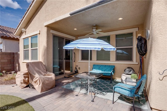 view of patio with a ceiling fan and fence