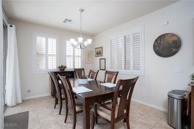 dining room with light tile patterned floors, baseboards, visible vents, and a chandelier