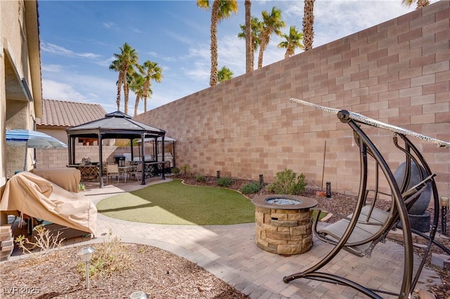 view of patio / terrace with a gazebo, fence, and an outdoor fire pit