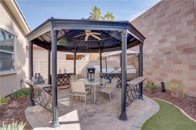 view of patio featuring a gazebo, outdoor dining space, and fence