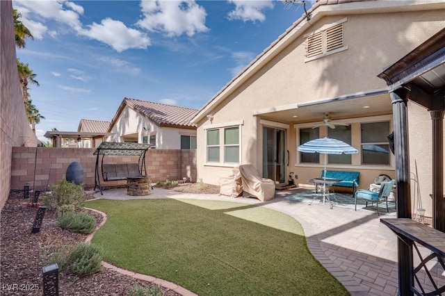 exterior space with a fenced backyard, stucco siding, a ceiling fan, and a patio