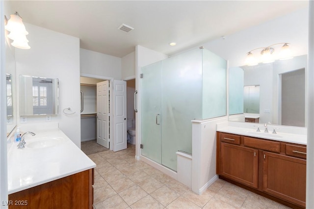 609 Viale Machiavelli Ln, Henderson, NV 89011 - bathroom with a stall shower, toilet, two vanities, and tile patterned flooring