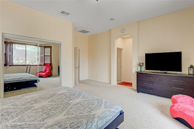 bedroom with arched walkways, visible vents, carpet flooring, and baseboards