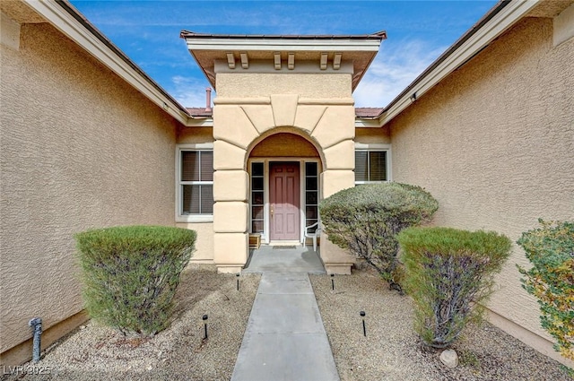 property entrance featuring stucco siding and a tiled roof