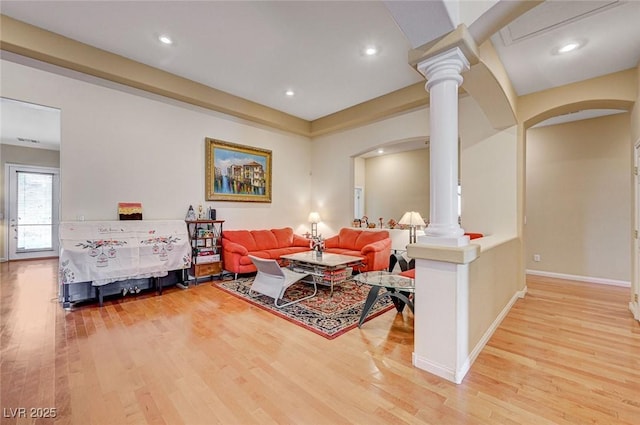 living area with recessed lighting, decorative columns, wood finished floors, and baseboards