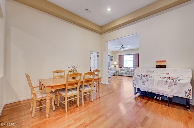 dining area featuring visible vents, baseboards, and light wood finished floors