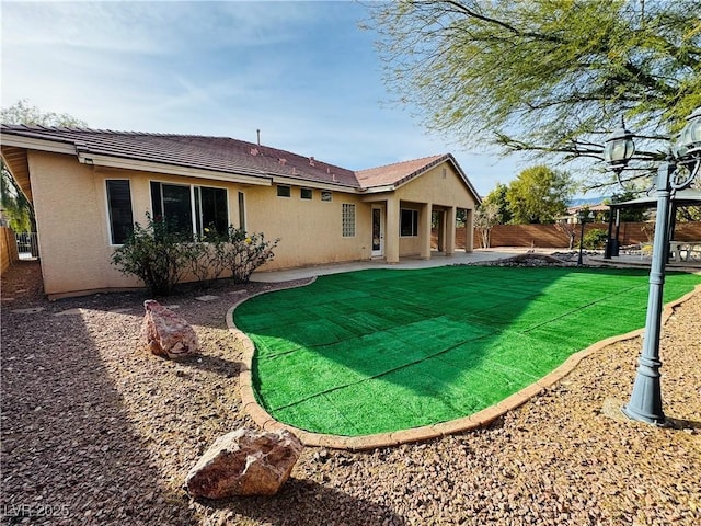 rear view of house with a patio area, a fenced backyard, and stucco siding