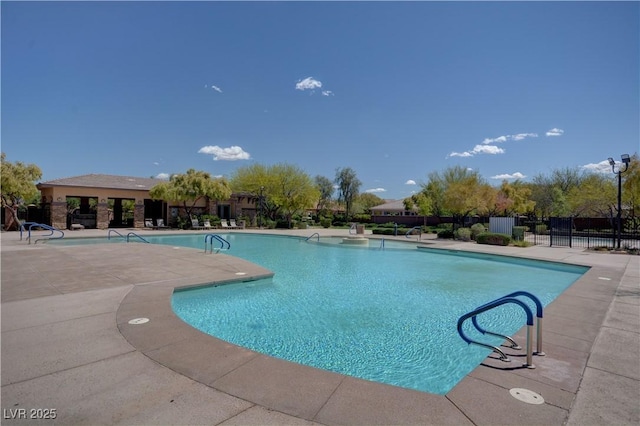 community pool with a patio and fence