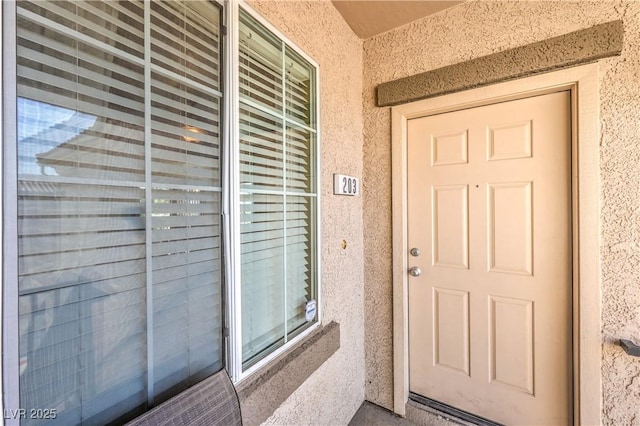 entrance to property featuring stucco siding