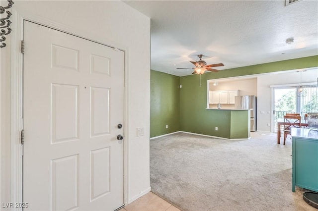 spare room featuring baseboards, light carpet, and ceiling fan