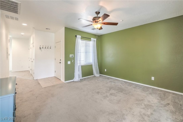 unfurnished room with light carpet, visible vents, baseboards, and a ceiling fan