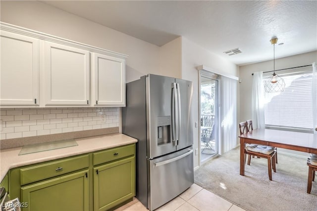 kitchen featuring visible vents, light carpet, stainless steel refrigerator with ice dispenser, white cabinets, and green cabinetry