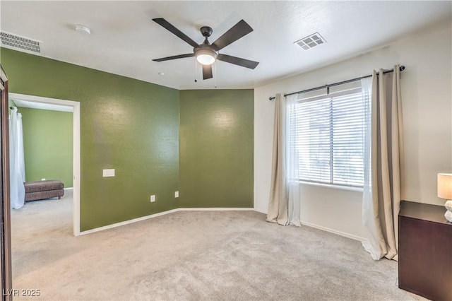 spare room featuring visible vents, baseboards, carpet, and a ceiling fan