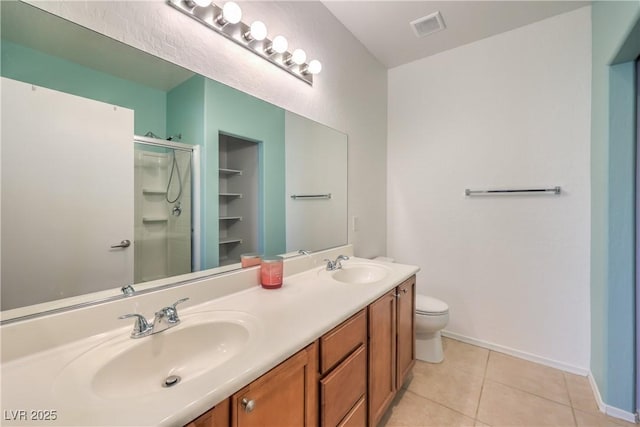 bathroom featuring tile patterned flooring, visible vents, a shower stall, and a sink