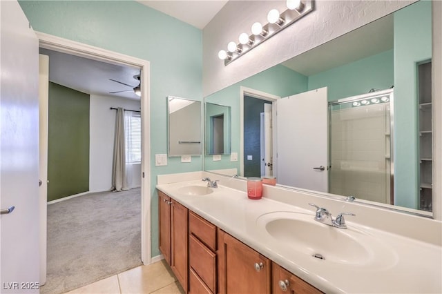 full bathroom featuring tile patterned flooring, double vanity, a shower with shower door, and a sink