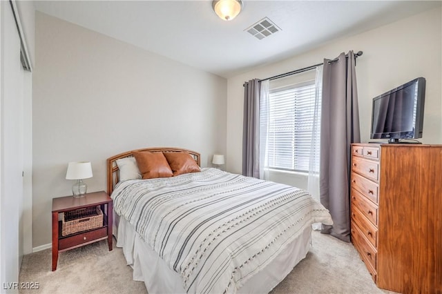 bedroom with visible vents and light carpet