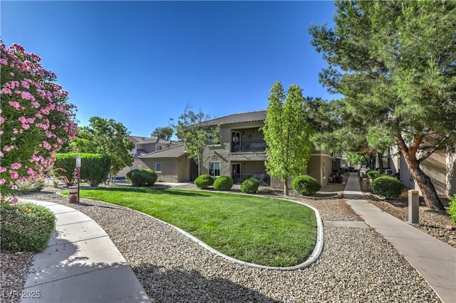 obstructed view of property featuring stucco siding and a front yard