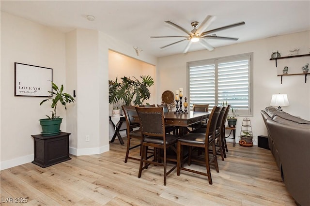 dining area featuring baseboards, ceiling fan, and light wood finished floors