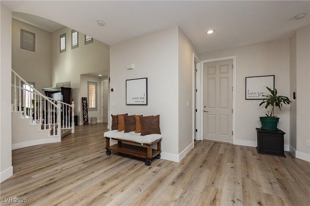 foyer entrance featuring recessed lighting, baseboards, light wood-style floors, and stairs