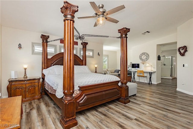 bedroom with visible vents, baseboards, decorative columns, wood finished floors, and refrigerator