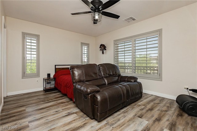 living area featuring wood finished floors, visible vents, and baseboards