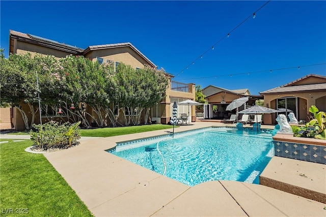 view of pool with a fenced in pool, fence, a lawn, and a patio area