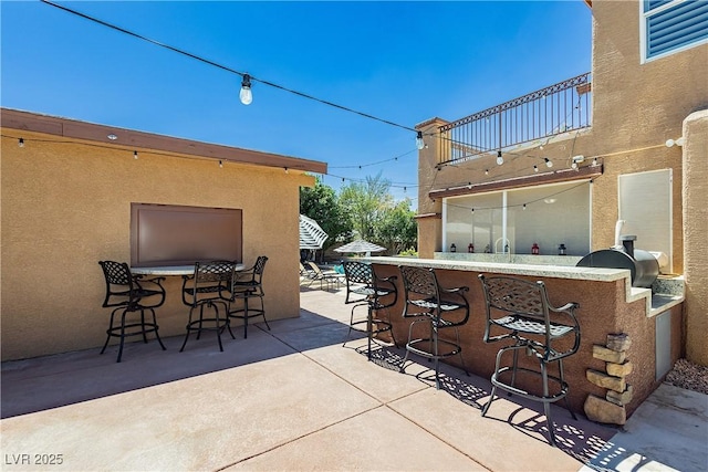 view of patio / terrace with an outdoor bar, a balcony, and a grill