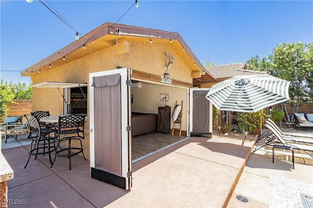 exterior space with stucco siding, a patio, and fence