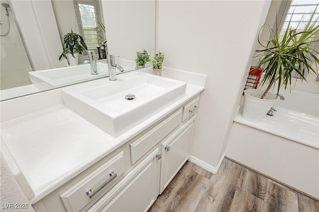 bathroom with vanity, wood finished floors, and baseboards