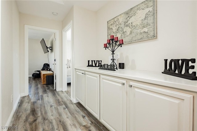 hall with baseboards and light wood-style flooring