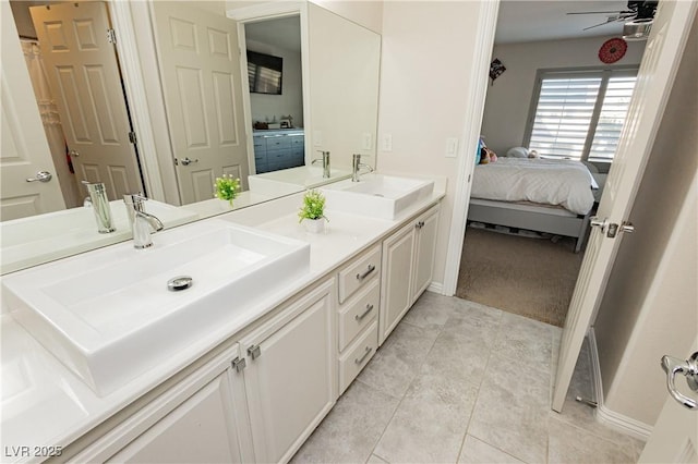 bathroom featuring tile patterned floors, ensuite bath, a ceiling fan, and a sink