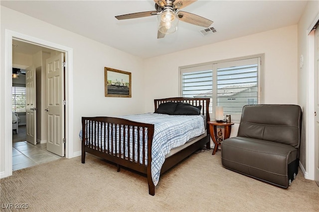 bedroom featuring visible vents, light colored carpet, baseboards, and a ceiling fan