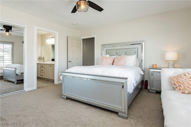 bedroom with a ceiling fan, light colored carpet, baseboards, and connected bathroom