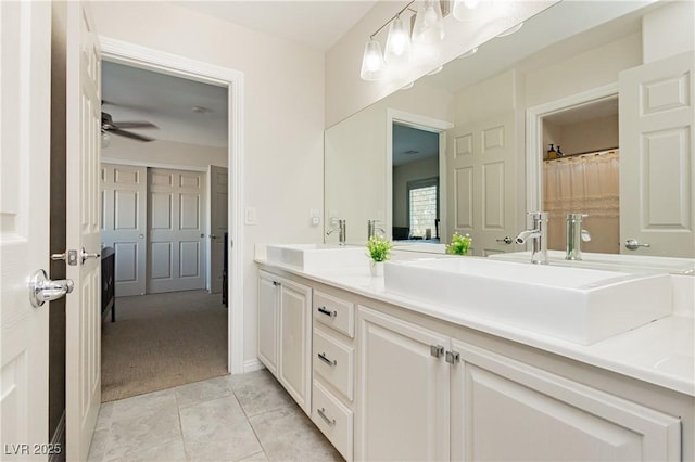 bathroom featuring tile patterned flooring, double vanity, a ceiling fan, and a sink