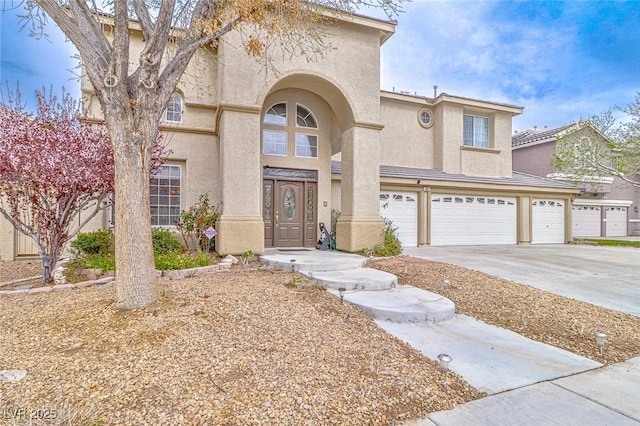 mediterranean / spanish-style house featuring stucco siding, driveway, and a garage