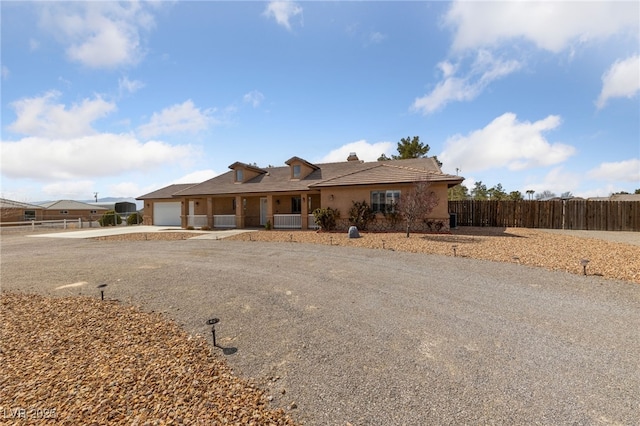 ranch-style house with stucco siding, driveway, a garage, and fence