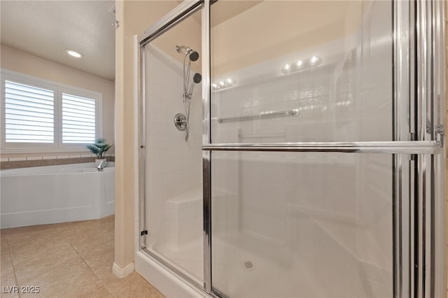 bathroom featuring tile patterned floors, a garden tub, and a shower stall