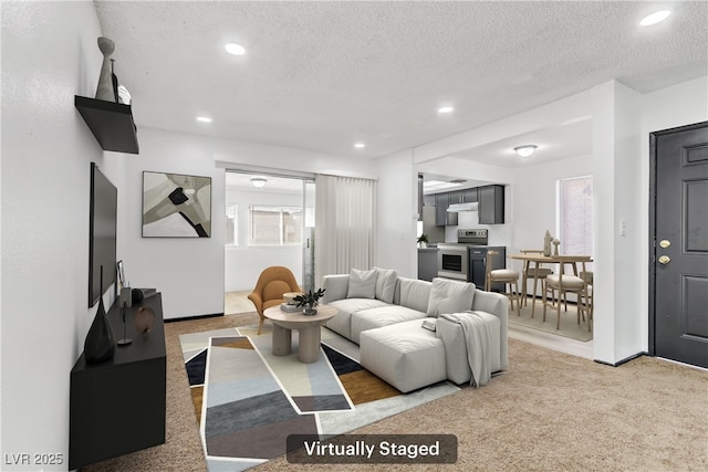 living room with recessed lighting, light colored carpet, and a textured ceiling