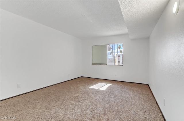 carpeted spare room with a textured ceiling