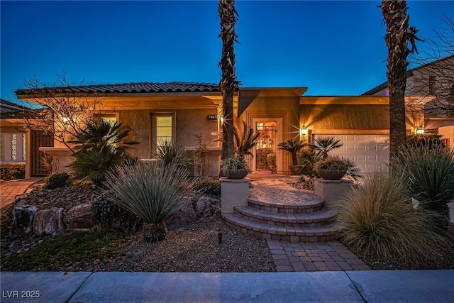 view of front of property featuring stucco siding and a garage