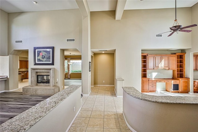 interior space featuring light tile patterned floors, visible vents, and a premium fireplace