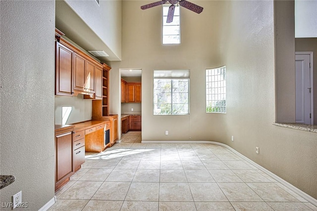 kitchen with plenty of natural light, a ceiling fan, light tile patterned floors, and built in study area