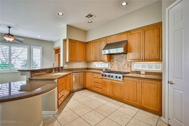 kitchen with visible vents, a sink, appliances with stainless steel finishes, a peninsula, and extractor fan