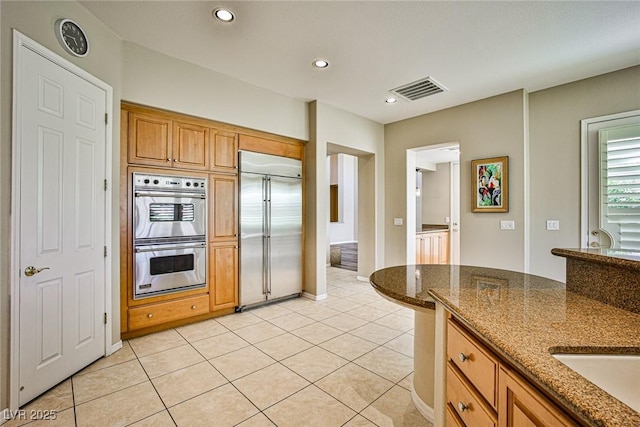 kitchen featuring visible vents, recessed lighting, stainless steel appliances, dark stone counters, and light tile patterned floors