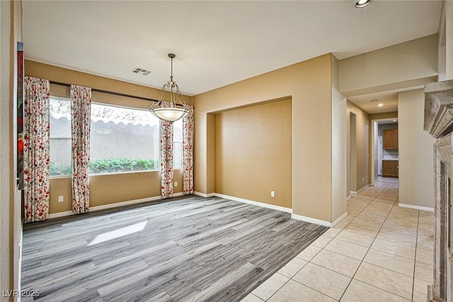 unfurnished dining area featuring visible vents, baseboards, and light wood-style floors