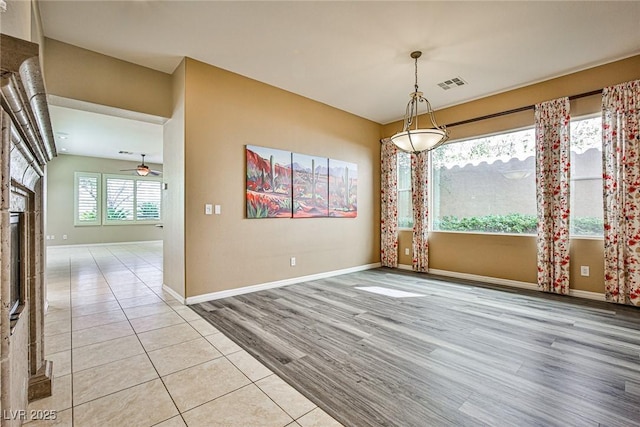 unfurnished dining area with light wood finished floors, visible vents, ceiling fan, and baseboards